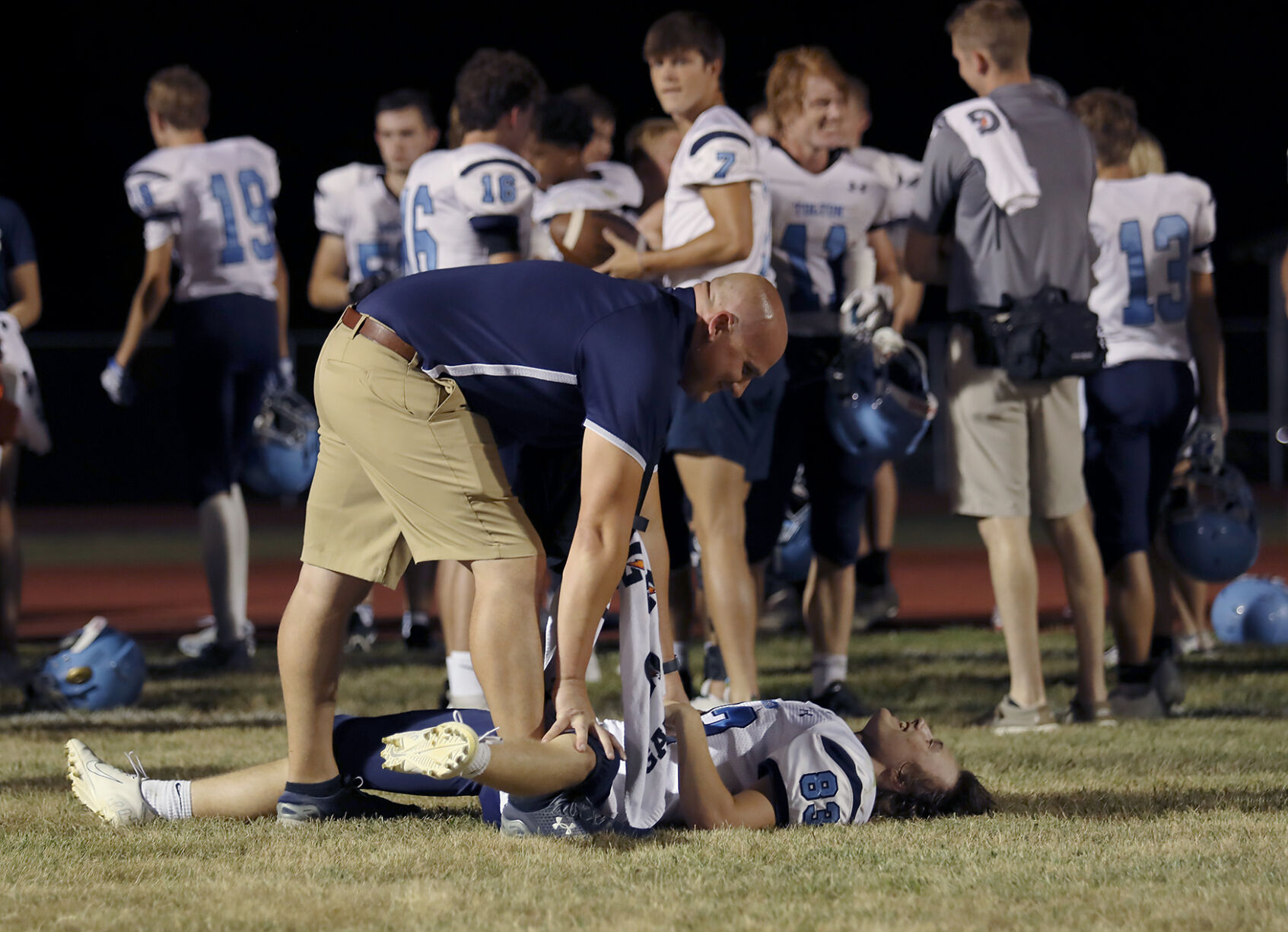 Tolton athletic trainer Bryce Roark helps football player